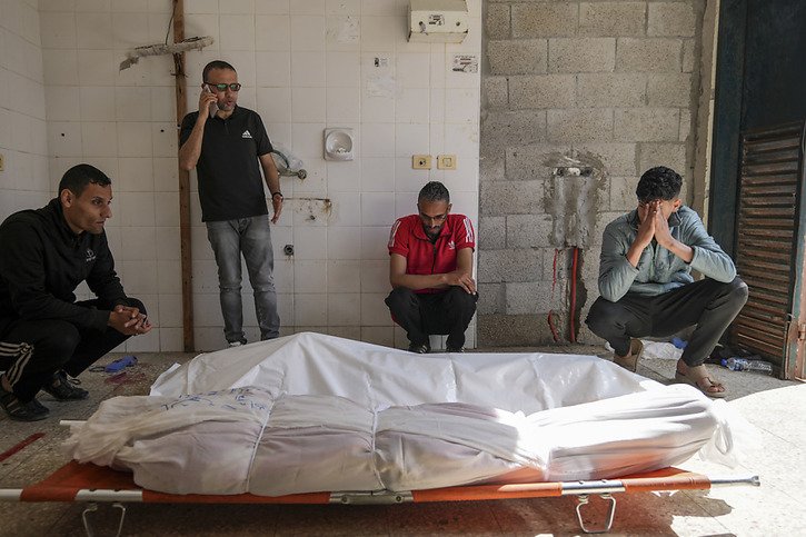 Des Palestiniens samedi près des corps de proches tués lors d'un raid israélien à Deir al Balah, dans la bande de Gaza. © KEYSTONE/AP/Abdel Kareem Hana